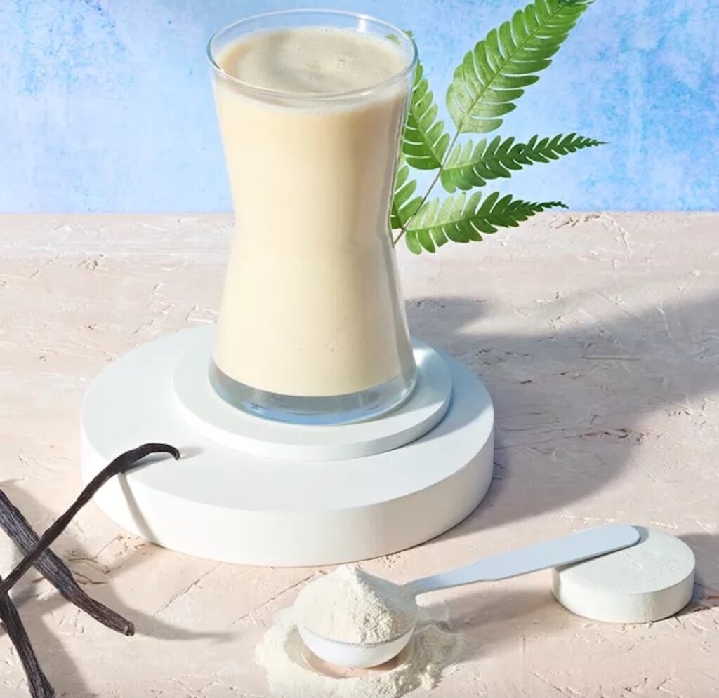Verre de boisson protéinée Herbalife vanille avec poudre et gousse, riche en protéines végétales